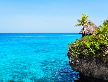 Jamaica, Negril, Traditional huts on rocky coastline