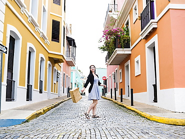 Puerto Rico, San Juan, Woman with shopping bag walking city streets