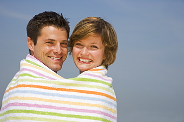 Couple wrapped in beach towel