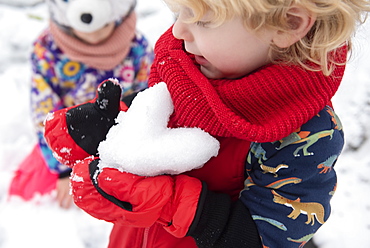 Boy holding snow heart