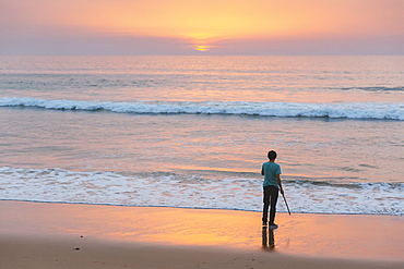 Young man on beach at sunset in Lisbon, Portugal