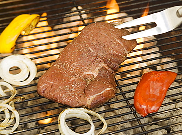 Steak and vegetables cooking on grill