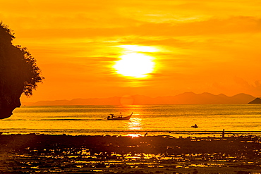 Silhouette of boat at sunset in West Railay, Thailand