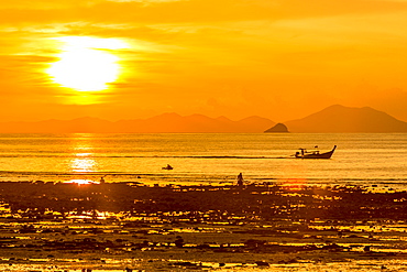 Silhouette of boat at sunset in West Railay, Thailand