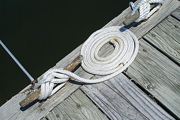 Coiled rope tied to mooring on pier