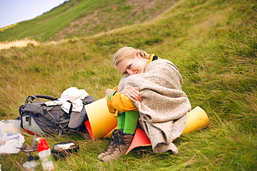 Camping woman wrapped in blanket