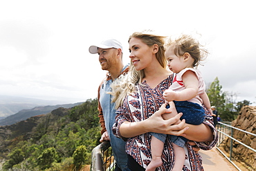 Parents with baby girl on mountain walkway