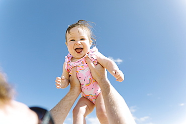 Father holding his baby girl aloft