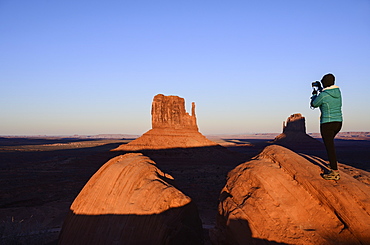 Woman photographing butte in Monument Valley, Arizona, USA