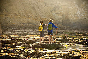 Teenage boys on rocks by tide pool in La Jolla, California