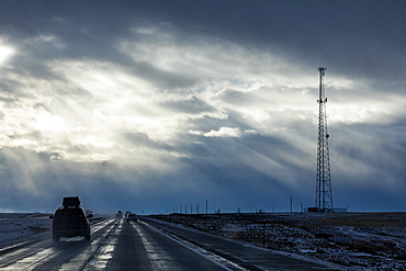 Country road with snow under overcast sky