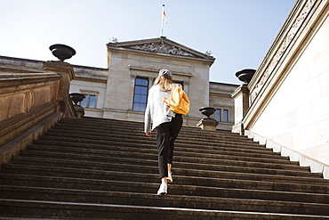 Young woman walking on steps in Berlin, Germany