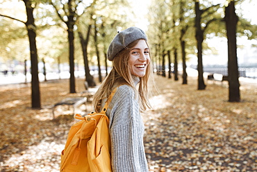 Young woman with yellow backpack in park in Berlin, Germany