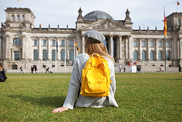 Young woman sitting in park by Reichstag in Berlin, Germany