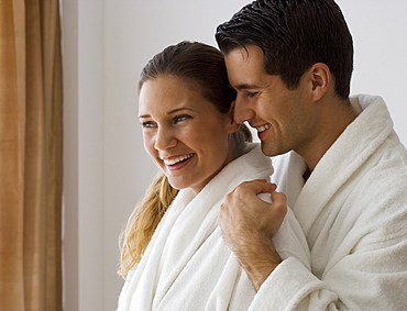 Couple in bathrobes hugging