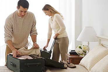 Couple unpacking in hotel room