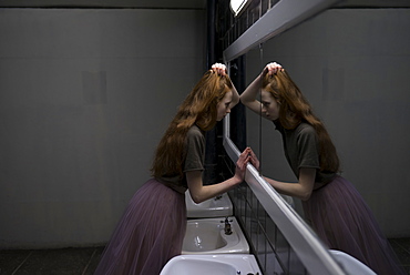 Young woman leaning on bathroom mirror