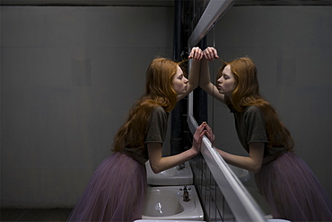 Young woman leaning on bathroom mirror