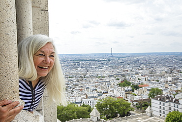 Smiling woman by cityscape from Sacre Coeur in Paris, France