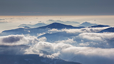 Fog over mountain at sunrise in Piedmont, Italy