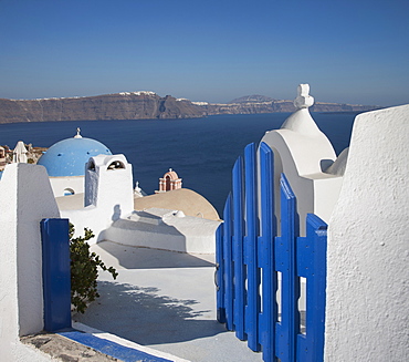 Open blue gate by whitewashed church in Santorini, Cyclades Islands, Greece