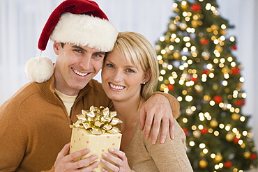 Portrait of couple holding Christmas gift