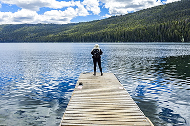 Woman standing on jetty on lake in Stanley, Idaho, USA