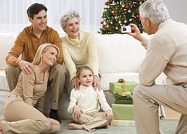 Grandfather taking photograph of family on Christmas