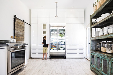 Boy looking in cupboard in kitchen