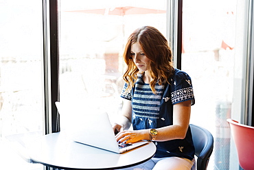 Woman using laptop in cafe