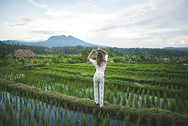 Rear view of woman standing in rice paddy in Bali, Indonesia