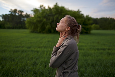 Young woman with her eyes closed in field