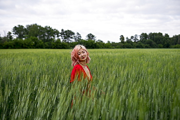 Woman with pink hair in wheat field