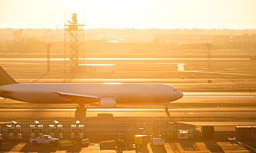 Airplane on runway at sunset