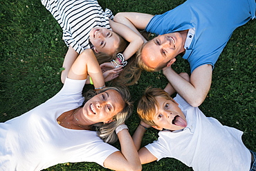 Family lying on grass with their hands behind their heads