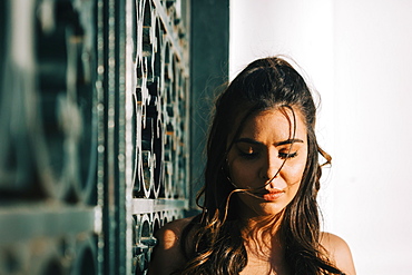 Woman looking down by metal gate