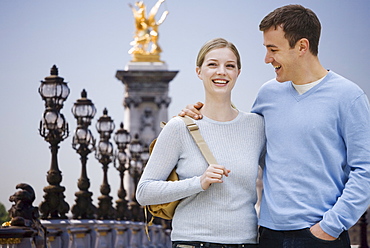 Couple smiling with golden statue in background