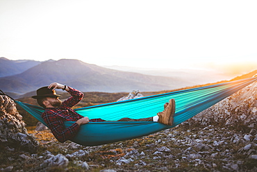 Man sleeping on hammock in mountain range