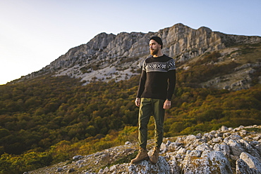 Man standing on rock by mountain