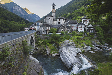 Bell tower by bridge and river in Ticino, Switzerland