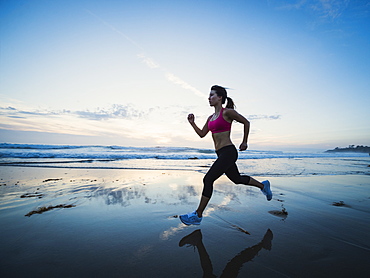 Woman wearing sports clothes running on beach