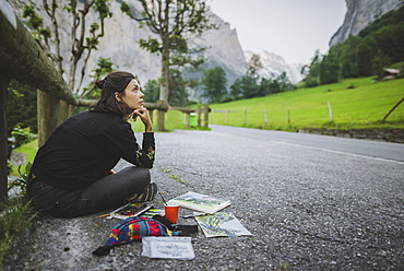 Young woman painting mountains on road