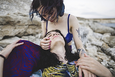 Young man lying in woman's lap on beach