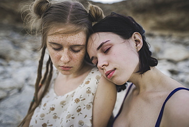 Young women sitting together on beach