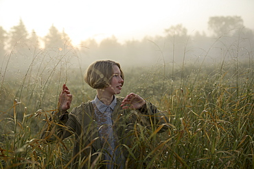 Young woman in field of long grass