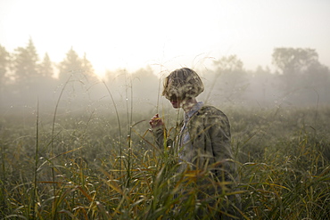 Young woman in field of long grass