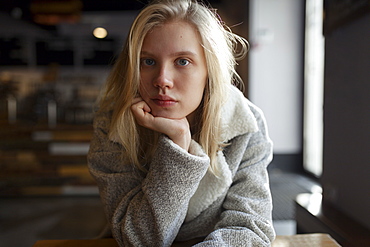 Young woman with wool coat in cafe