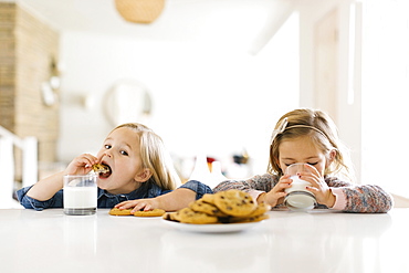 Girls eating milk and cookies