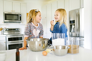 Smiling girls baking cookies