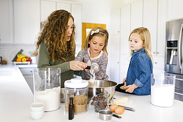 Woman baking cookies with her daughters